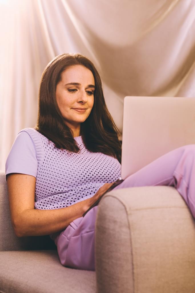 A woman reading her phone and smiling 