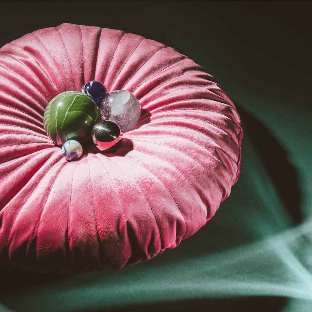 A collection of balls sits in the middle of a poofy pink pillow. The whole thing looks a bit like pearls in an oyster. Zendesk will protect you and your data, like the oyster shell protects the treasure inside.